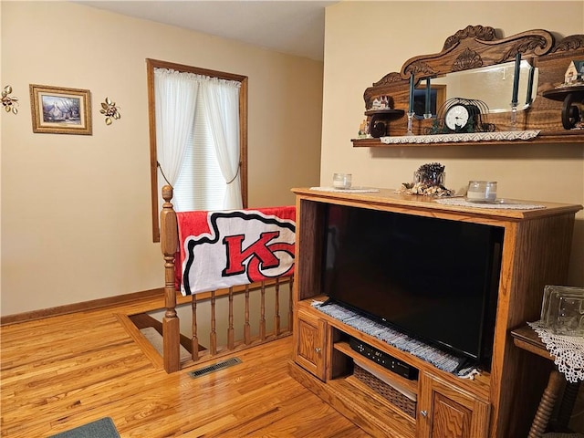 interior space featuring baseboards, visible vents, and wood finished floors