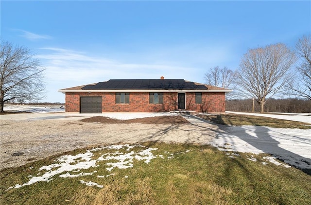 view of front of property featuring a garage and solar panels