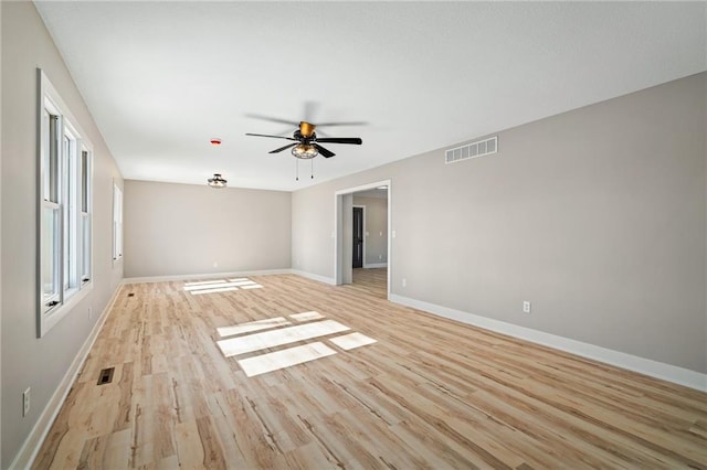 empty room with ceiling fan and light hardwood / wood-style flooring