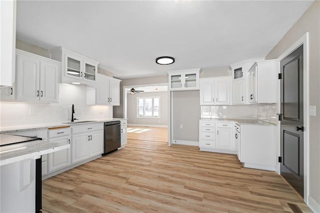 kitchen featuring dishwasher, sink, white cabinets, light stone counters, and light hardwood / wood-style floors