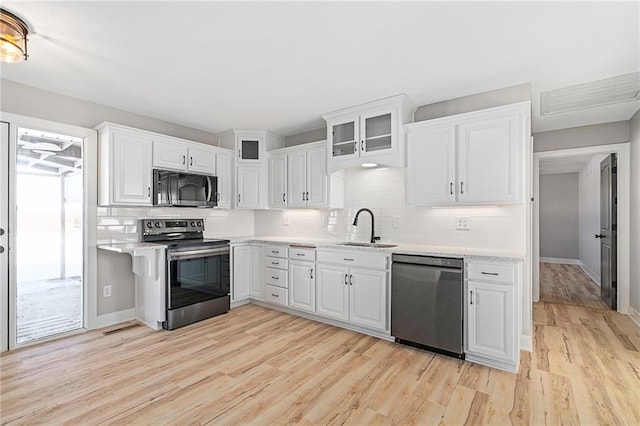 kitchen with white cabinetry, sink, stainless steel appliances, and light wood-type flooring