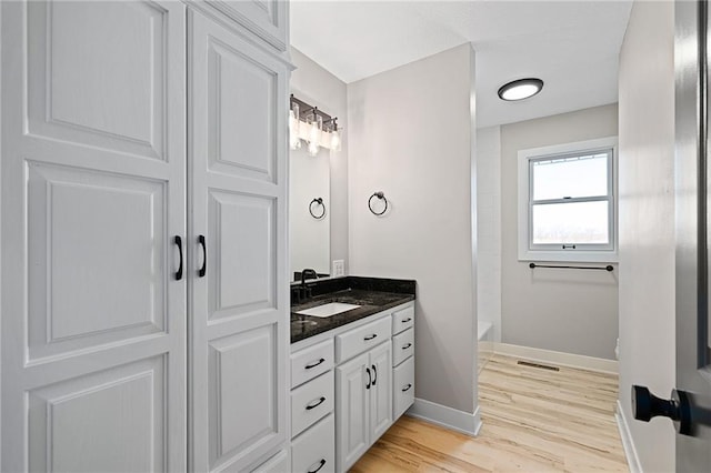 bathroom with vanity, wood-type flooring, and shower / bathtub combination