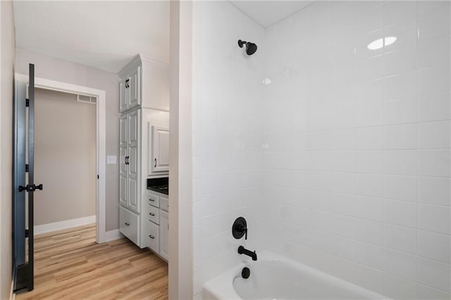 bathroom with vanity, wood-type flooring, and bathtub / shower combination