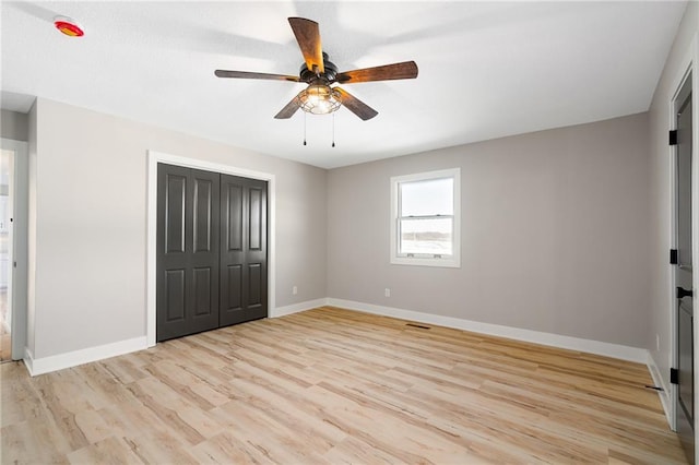 unfurnished bedroom featuring light hardwood / wood-style floors, a closet, and ceiling fan