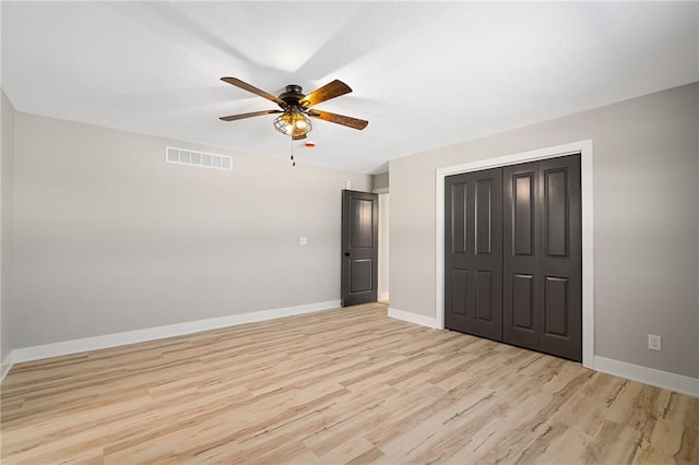 unfurnished bedroom featuring light hardwood / wood-style flooring, ceiling fan, and a closet