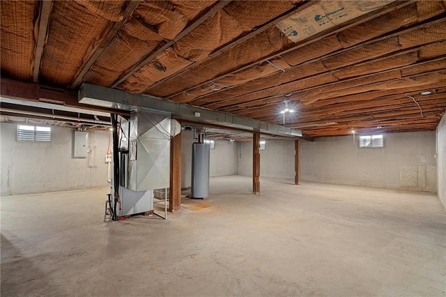 basement with gas water heater, a healthy amount of sunlight, heating unit, and electric panel