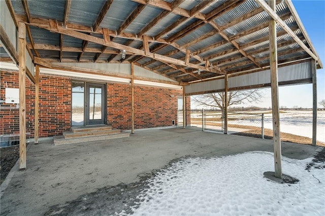 miscellaneous room featuring brick wall, lofted ceiling, and concrete floors