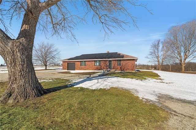 rear view of house featuring a lawn and solar panels