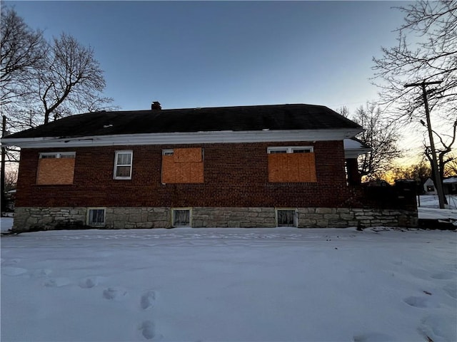 view of snow covered back of property