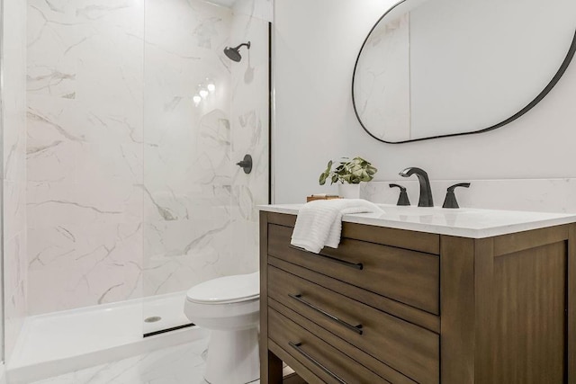 bathroom featuring vanity, tiled shower, and toilet