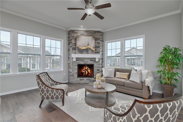 living room with crown molding, ceiling fan, dark hardwood / wood-style flooring, and a stone fireplace