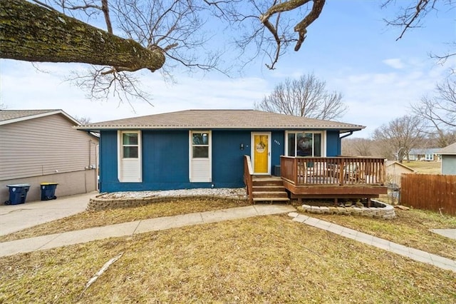 ranch-style house featuring a front yard and a deck