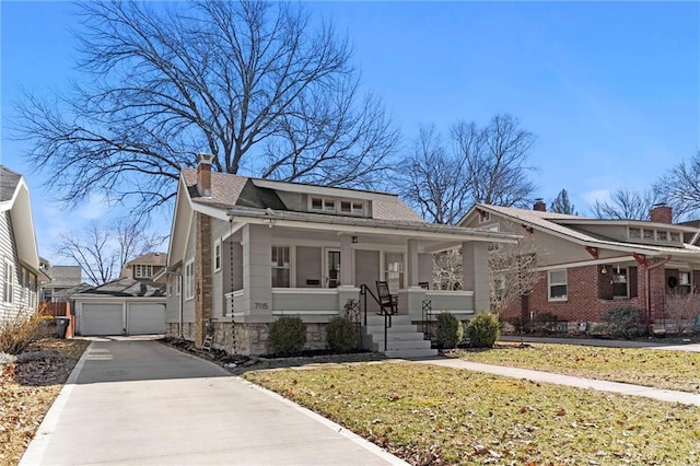 bungalow with a front yard, covered porch, a chimney, a garage, and an outdoor structure