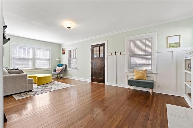 interior space with a decorative wall, ornamental molding, and hardwood / wood-style flooring