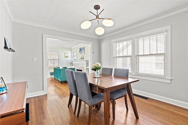 dining area featuring visible vents, plenty of natural light, ornamental molding, and hardwood / wood-style floors