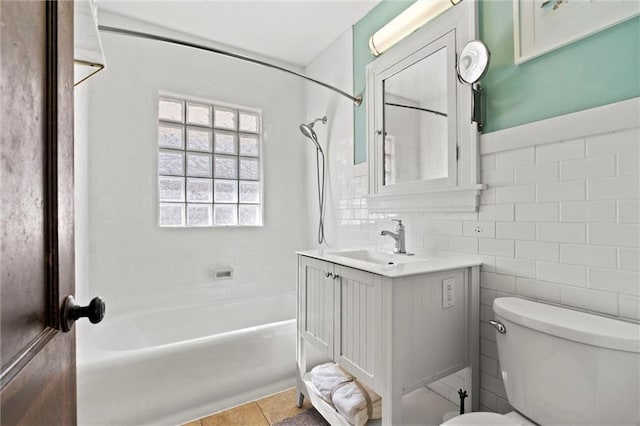 full bath featuring tile walls, toilet, bathtub / shower combination, tile patterned floors, and vanity