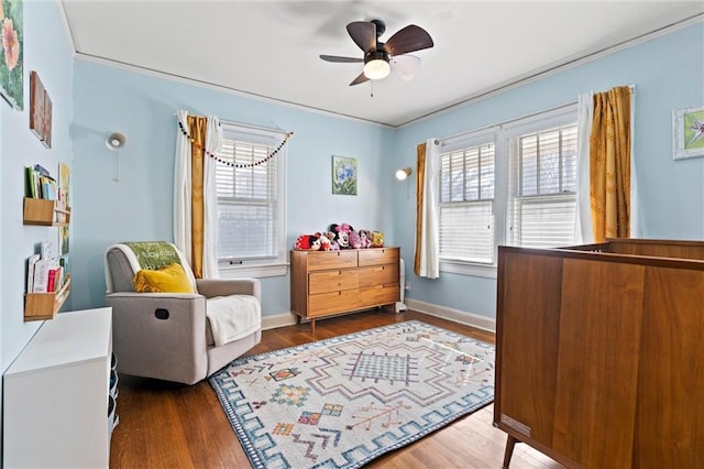 bedroom featuring ceiling fan, wood finished floors, baseboards, and ornamental molding