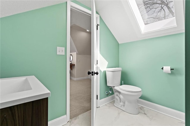 bathroom featuring baseboards, toilet, marble finish floor, and vaulted ceiling with skylight