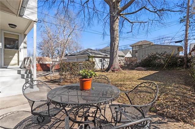 view of patio with an outbuilding and fence