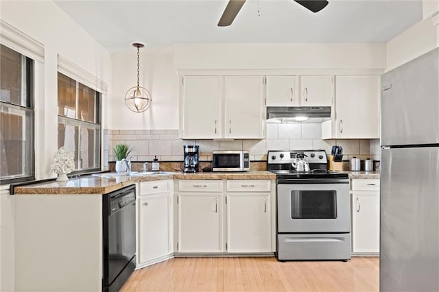 kitchen with hanging light fixtures, white cabinetry, appliances with stainless steel finishes, and tasteful backsplash