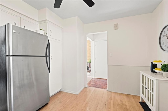 kitchen with white cabinetry, ceiling fan, stainless steel fridge, and light hardwood / wood-style flooring