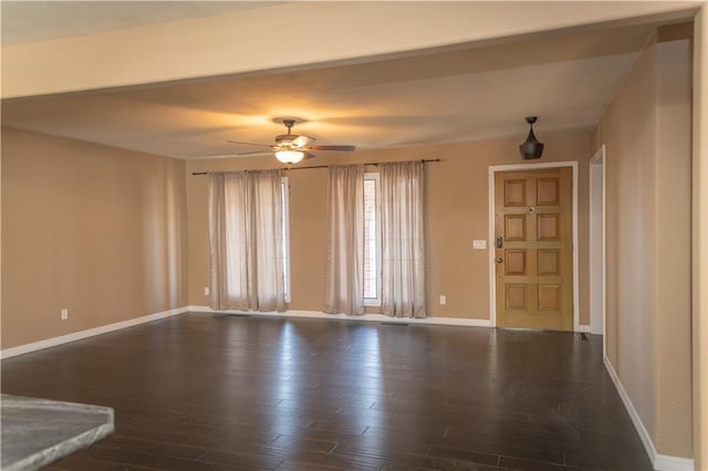 unfurnished living room with dark hardwood / wood-style flooring and ceiling fan