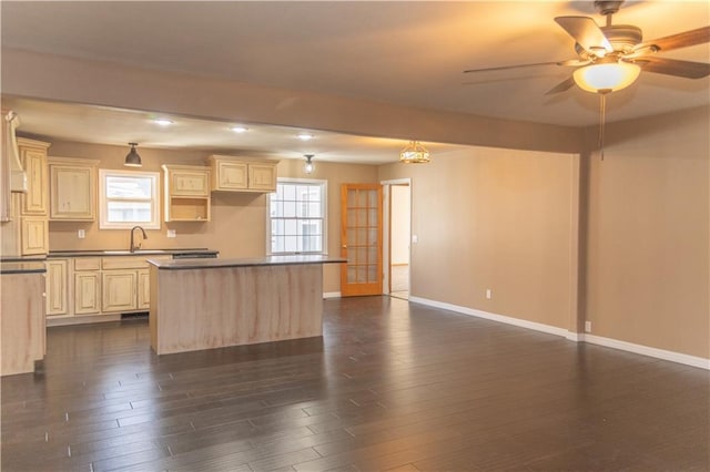 kitchen featuring sink, ceiling fan, dark hardwood / wood-style floors, a kitchen island, and cream cabinetry