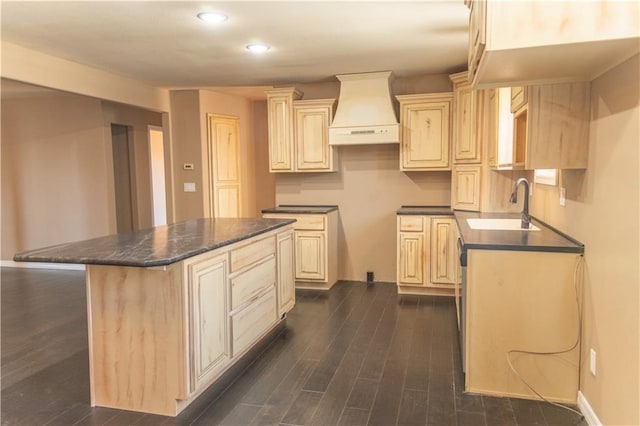 kitchen with sink, dark wood-type flooring, a center island, custom exhaust hood, and cream cabinetry