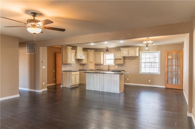 kitchen with ceiling fan, cream cabinets, custom range hood, and dark hardwood / wood-style flooring