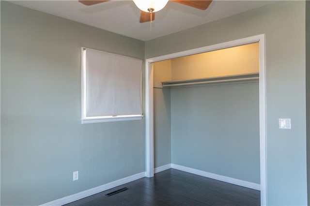 unfurnished bedroom featuring dark wood-type flooring, ceiling fan, and a closet