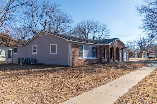 view of side of property featuring a garage and central AC