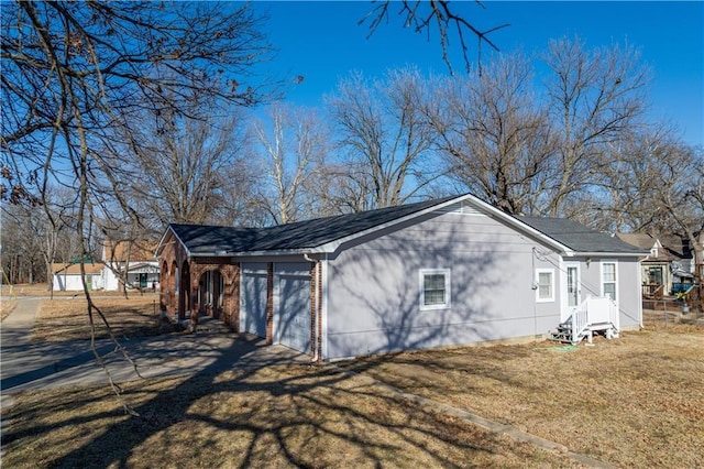 view of side of home with a garage and a lawn