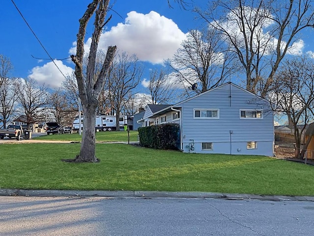 view of side of home featuring a residential view and a lawn