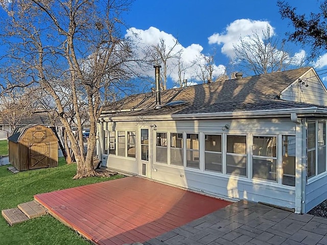 back of property with a deck and roof with shingles