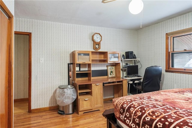 bedroom with light wood-type flooring, baseboards, and wallpapered walls