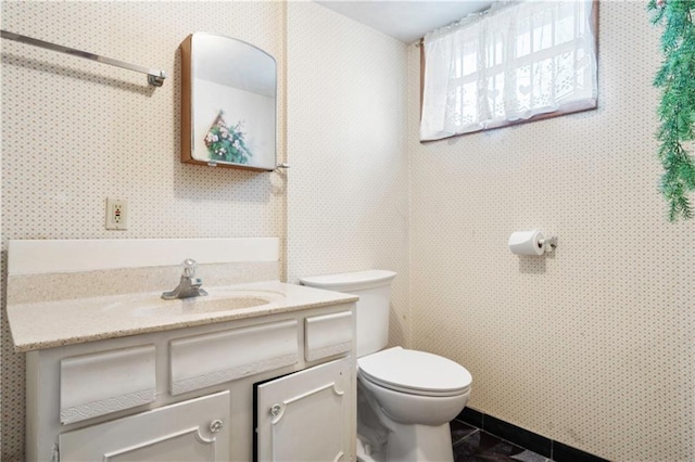 half bathroom featuring tile patterned flooring, vanity, and toilet