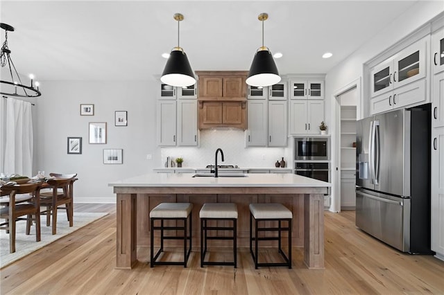 kitchen featuring white cabinetry, stainless steel appliances, and an island with sink