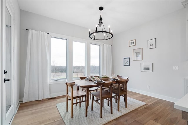 dining area with a chandelier and light hardwood / wood-style floors