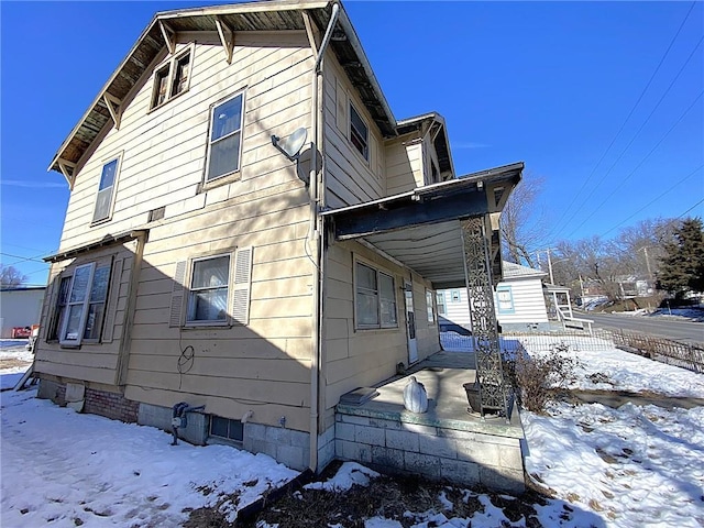 view of snow covered exterior with a porch