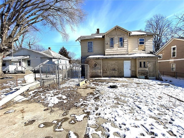 view of snow covered back of property