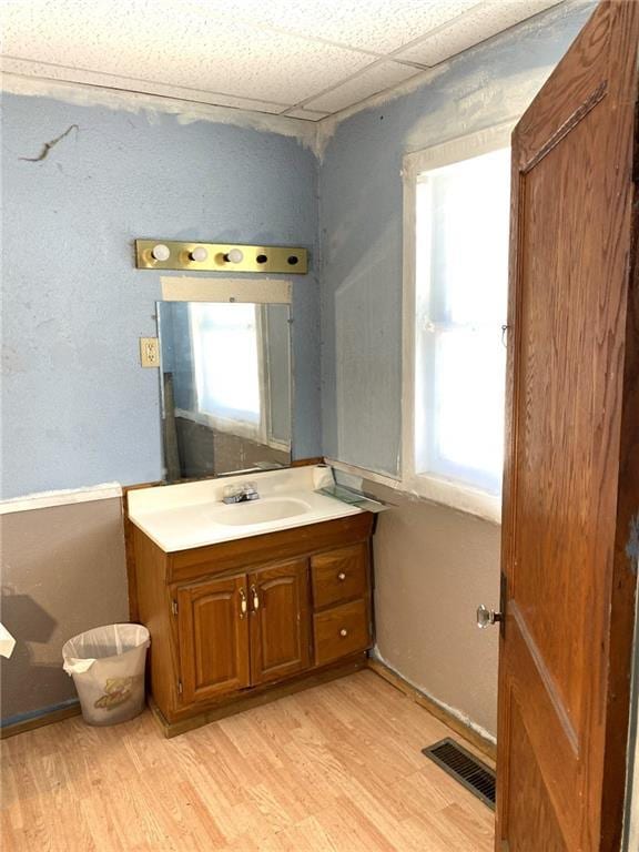 bathroom featuring a paneled ceiling, vanity, and hardwood / wood-style floors