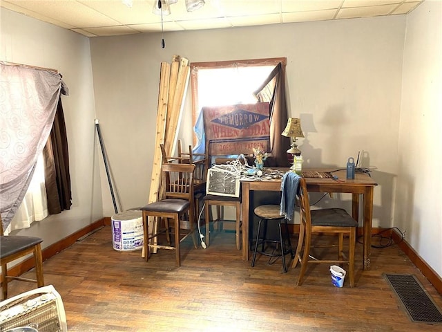 interior space featuring dark wood-type flooring and a drop ceiling