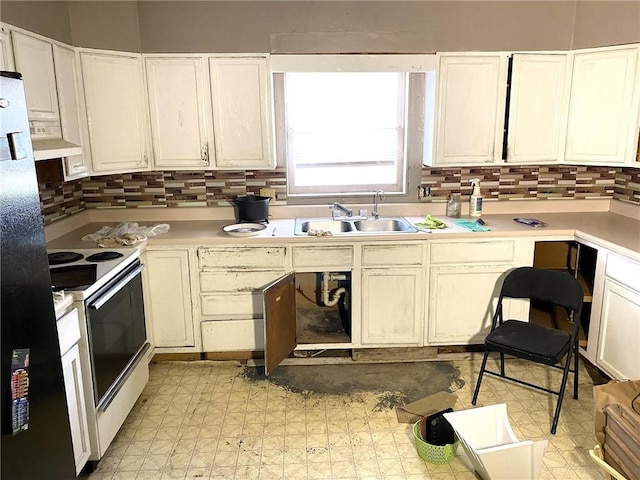 kitchen with black refrigerator, white electric range, tasteful backsplash, sink, and white cabinets