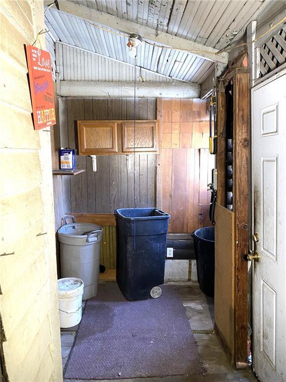 interior space featuring wooden ceiling and wooden walls