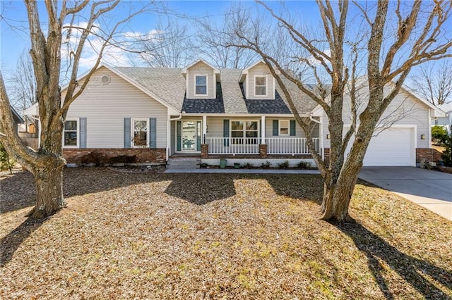 new england style home with driveway, a porch, roof with shingles, and brick siding