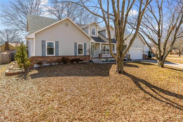 cape cod-style house with a garage, roof with shingles, covered porch, fence, and brick siding