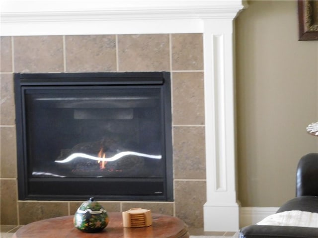 details featuring a tile fireplace and decorative columns