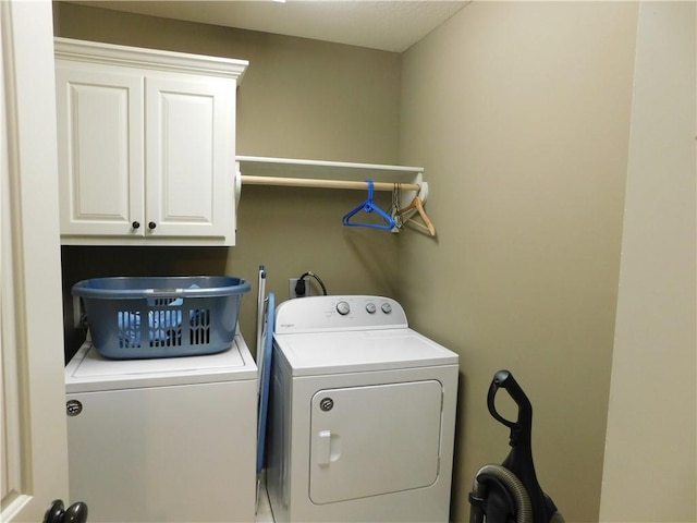 laundry room with separate washer and dryer and cabinets