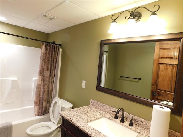 full bathroom with a drop ceiling, vanity, toilet, and shower / bath combo