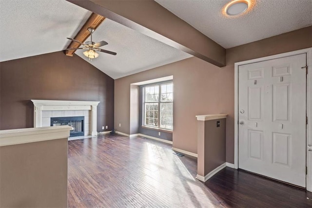 entryway with dark hardwood / wood-style floors, a fireplace, vaulted ceiling with beams, ceiling fan, and a textured ceiling